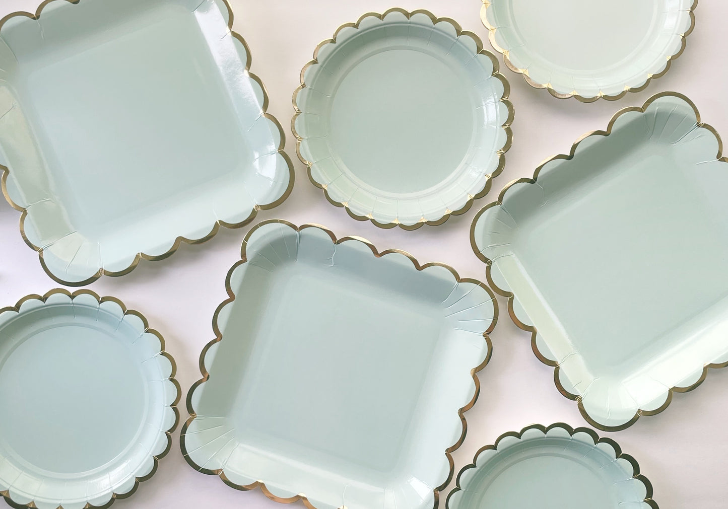 Large and small paper party plates. The plates are a pale pastel blue colour with gold foil scalloped trim.