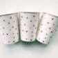 Paper party cups with a triangle pattern featuring green, orange, pink, blue and yellow colours.