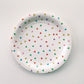 Large paper plates with a triangle pattern featuring green, orange, pink, blue and yellow colours.