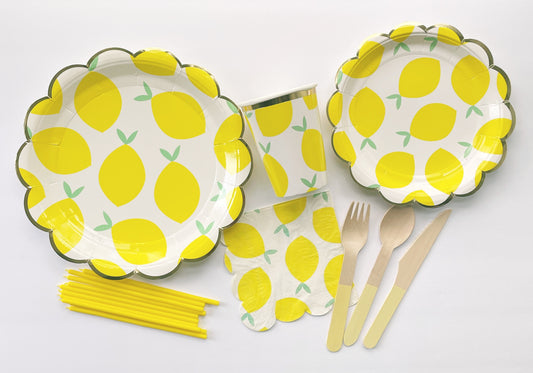 The complete Lemon Party Kit including large paper party plates, small paper party plates, paper cups, paper napkins, yellow dipped wooden utensils and tall yellow birthday candles. The lemon pattern includes yellow, green and white colours. The party plates have gold scalloped edges.