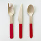 Red dipped wooden utensils. This cutlery set includes knives, spoons and forks.