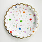 The large Celebration paper party plates have a gold foil scalloped edge. The celebration pattern features green, orange and blue balloons, ice cream cones, party hats, party garlands, birthday gifts and donuts.
