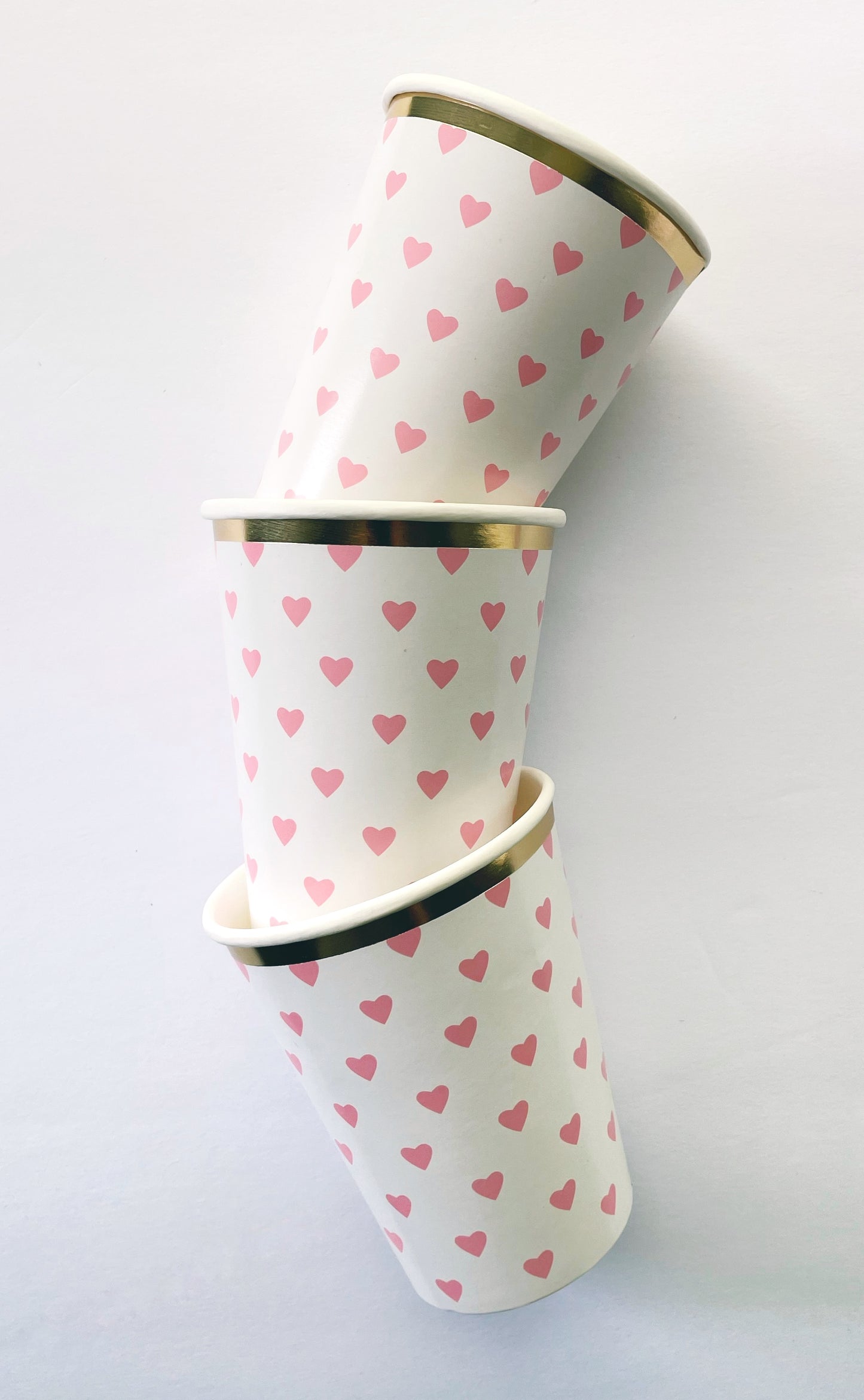 Pink and white party cups with gold foil detail. The cups have a pink heart pattern on them.