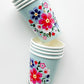 Blossom Party Kit paper party cups. The flower/floral pattern includes green, red and blue colours. 