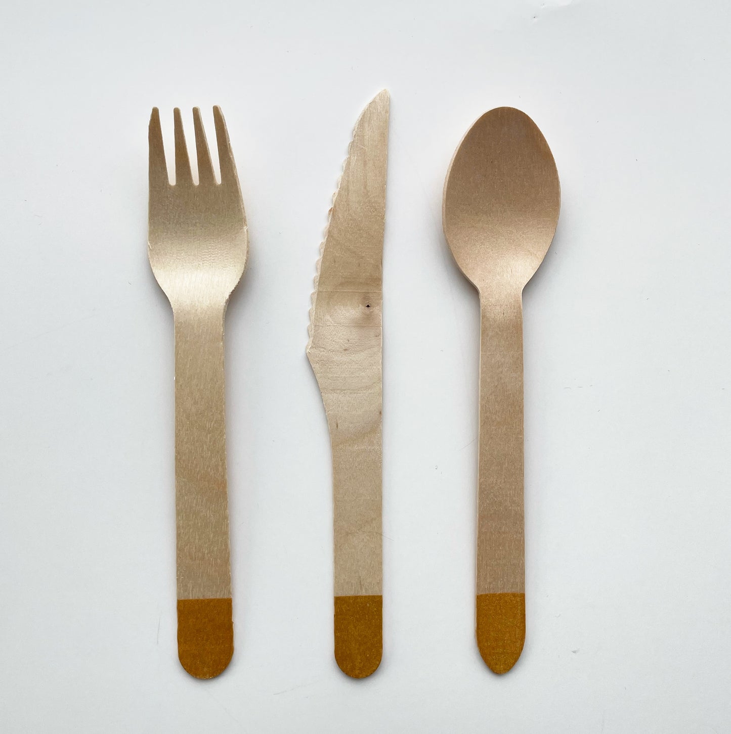 Gold dipped wooden utensils. This cutlery set includes knives, spoons and forks.