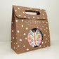 The Butterfly Party Kit in its kraft brown and white carry box. The box features a handle and a circular opening where you can see the contents inside.