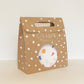 The Terrazzo Party Kit in its kraft brown and white carry box. The box features a handle and a circular opening where you can see the contents inside.