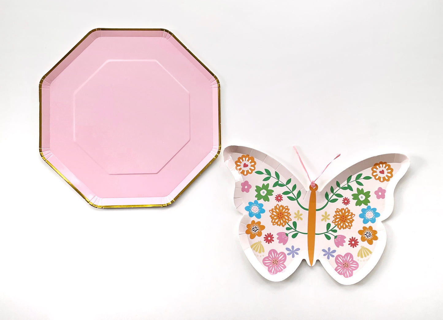 A large pink and gold paper party plate and a small butterfly shaped paper party plate. The Butterfly pattern includes pink, gold, blue, green and orange colours. The large party plates are in the shape of an octagon.