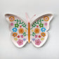 A small butterfly shaped paper party plate. The Butterfly pattern includes pink, gold, blue, green and orange colours. 