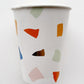 The paper party cups feature a terrazzo pattern including blue, orange and green colours with gold foil detail.