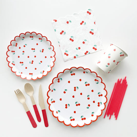 The complete Cherry Party Kit including large paper party plates, small paper party plates, paper cups, paper napkins, red dipped wooden utensils and tall red birthday candles. The cherry party kit features a red, green and white cherry print. The party plates feature red scalloped edges.