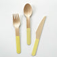 The Lemon party kit's yellow dipped wooden utensils, including a fork, spoon and knife.