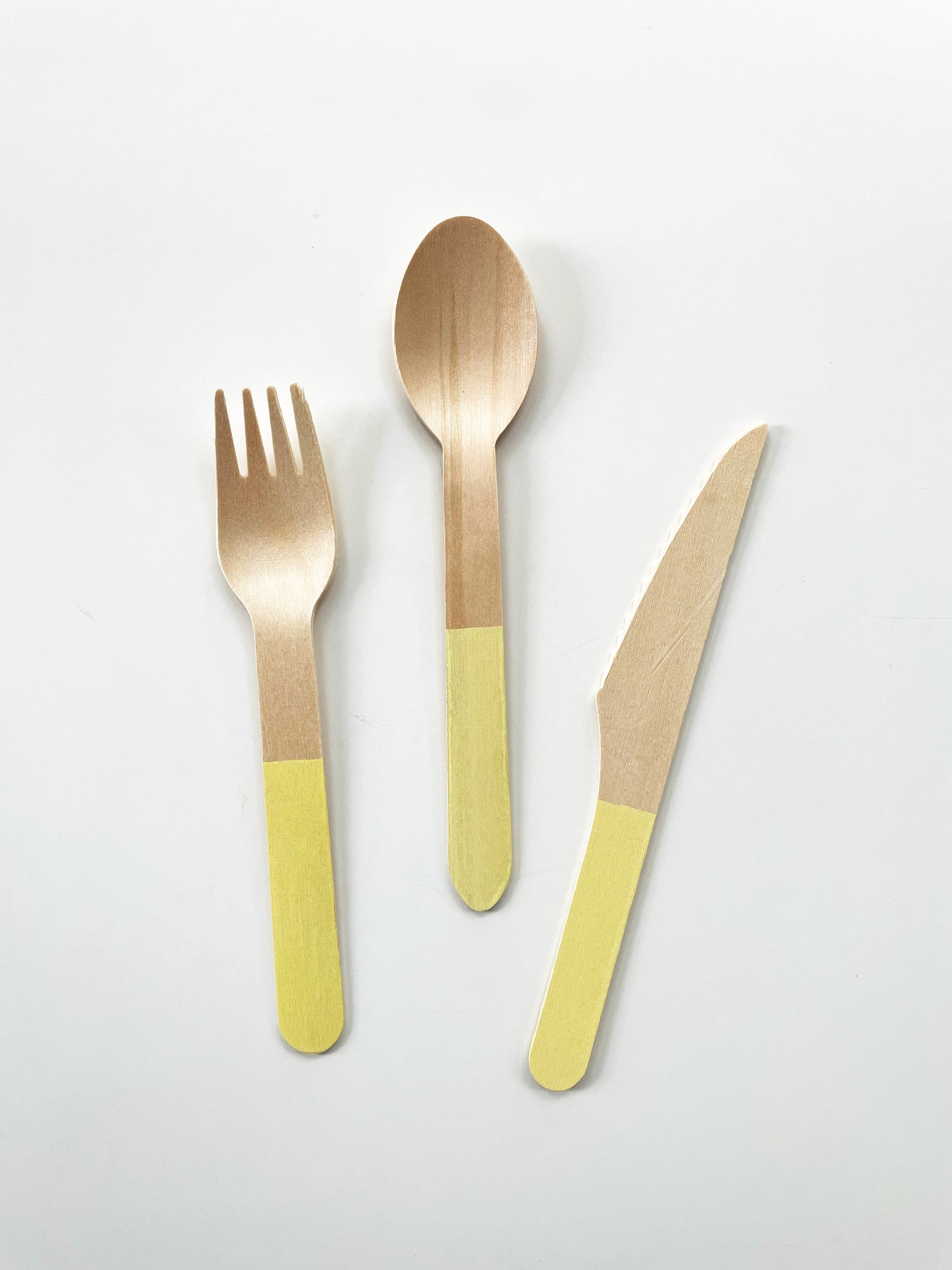 The Lemon party kit's yellow dipped wooden utensils, including a fork, spoon and knife.