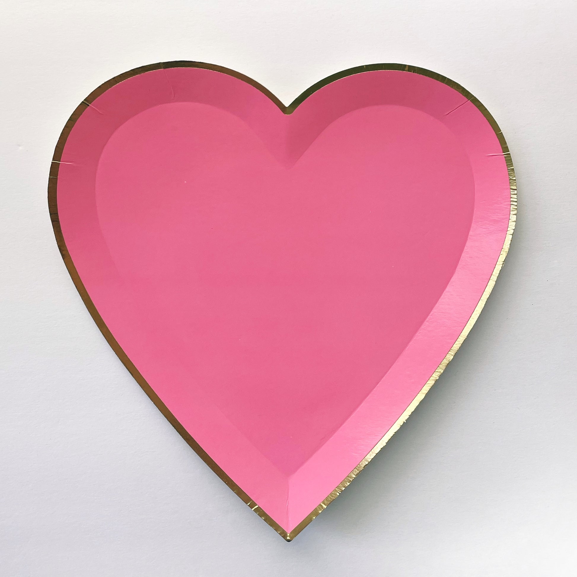 Bright pink heart shaped large party plate, with a gold foil edge.