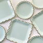 Large and small paper party plates. The plates are a pale pastel blue colour with gold foil scalloped trim.