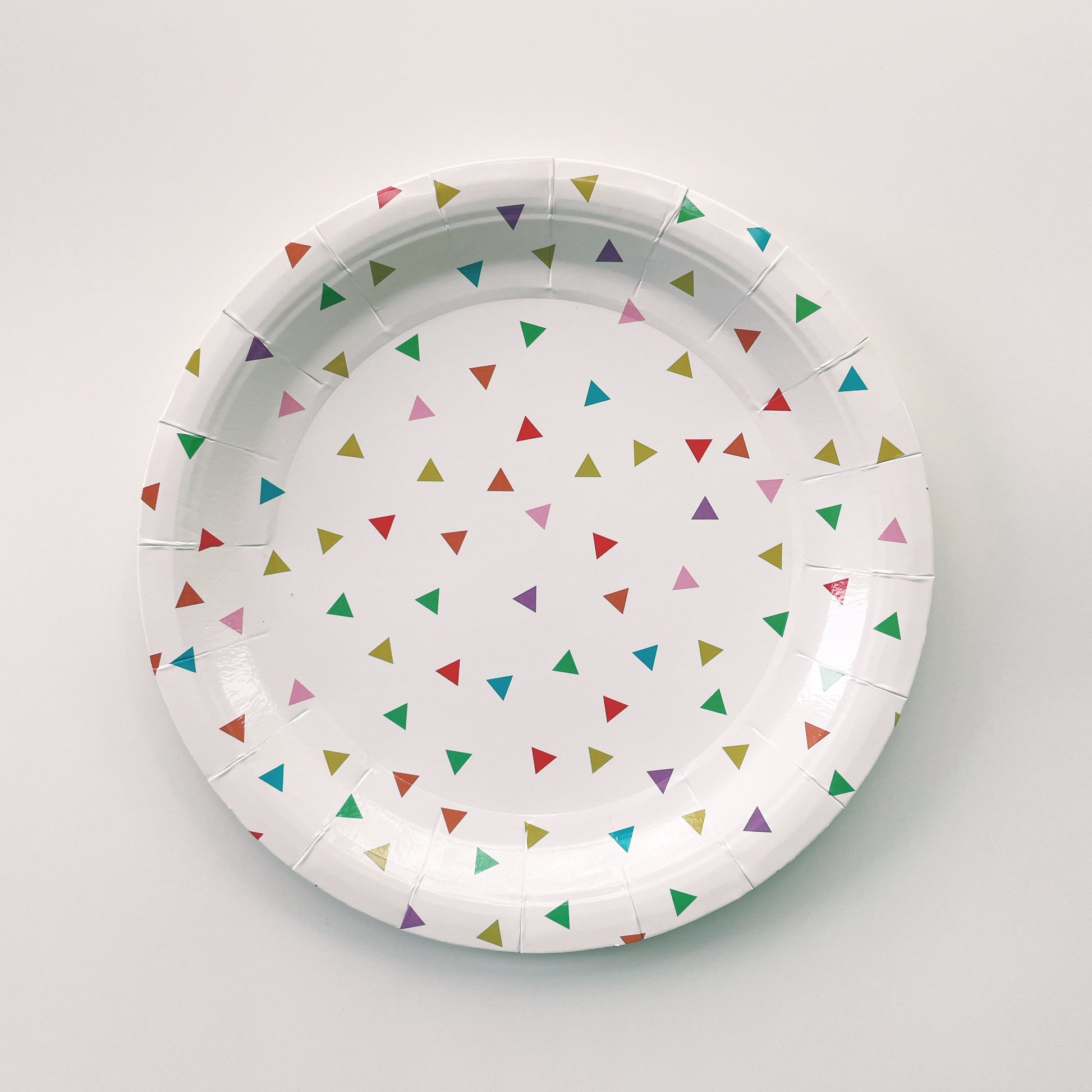 Large paper plates with a triangle pattern featuring green, orange, pink, blue and yellow colours.