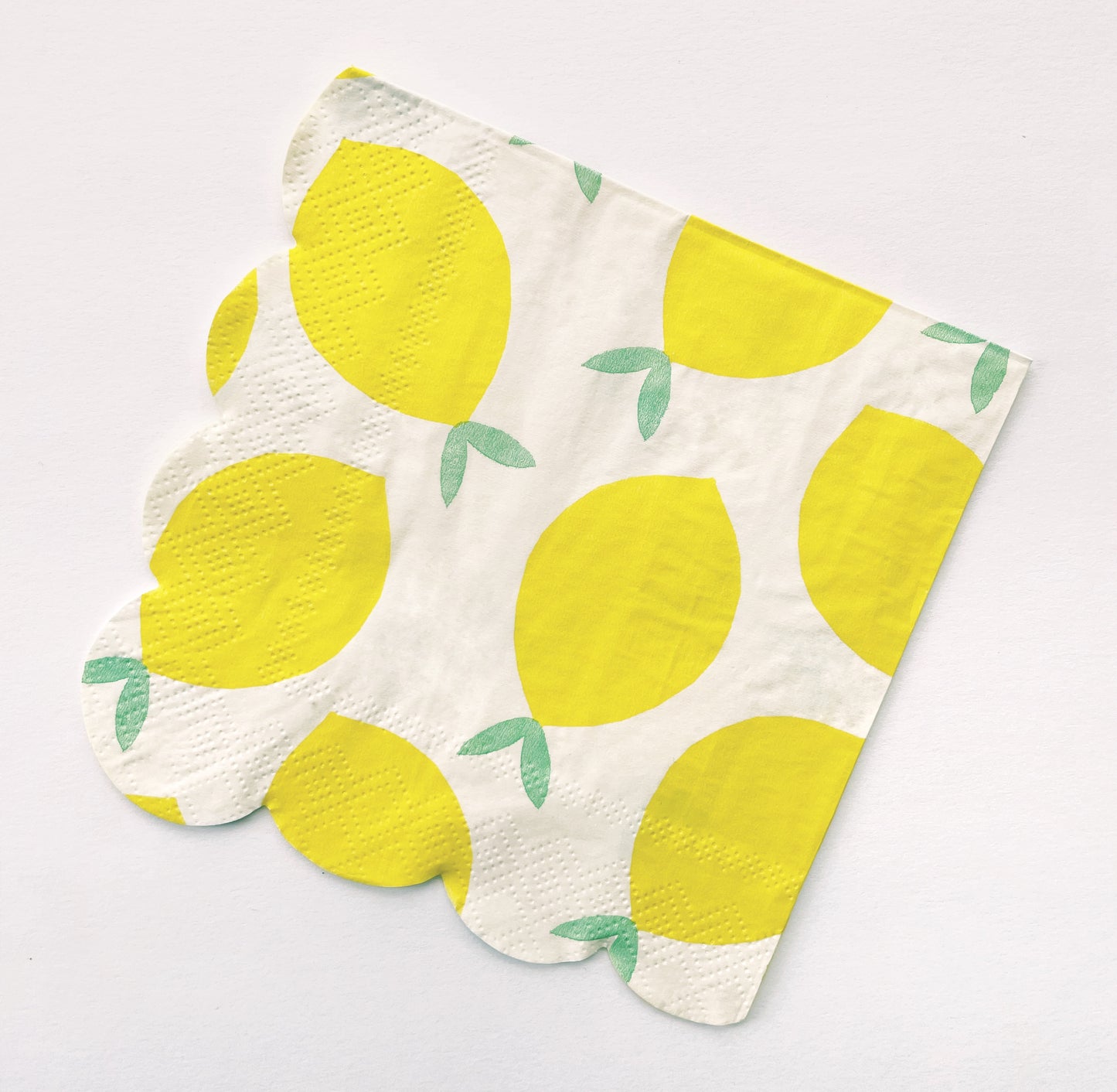 The Lemon Party Kit's paper party napkins. The lemon pattern includes yellow, green and white colours. The napkins have scalloped edges.