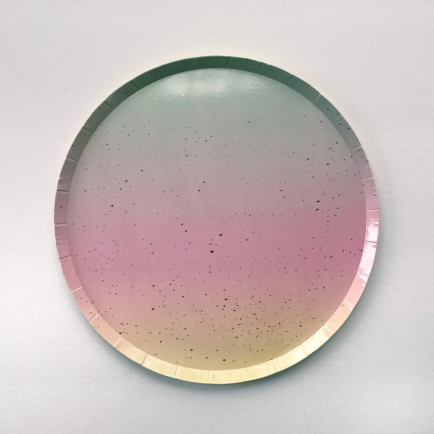 The Ombre Party Kit's small circular pink, yellow, green and gold paper party plates.