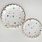 The large and small Celebration paper party plates have a gold foil scalloped edge. The celebration pattern features green, orange and blue balloons, ice cream cones, party hats, party garlands, birthday gifts and donuts.