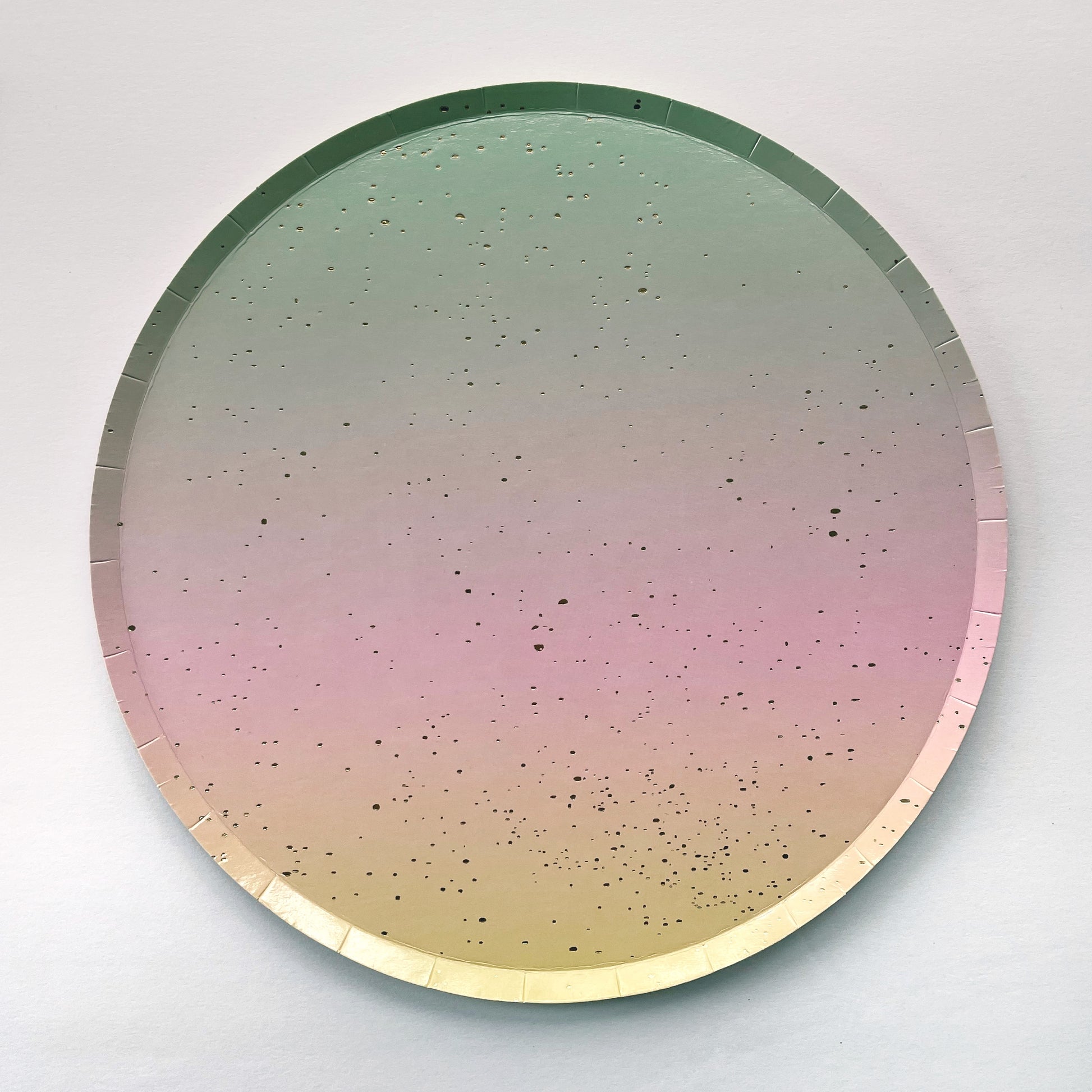 The Ombre Party Kit's large circular pink, yellow, green and gold paper party plates.