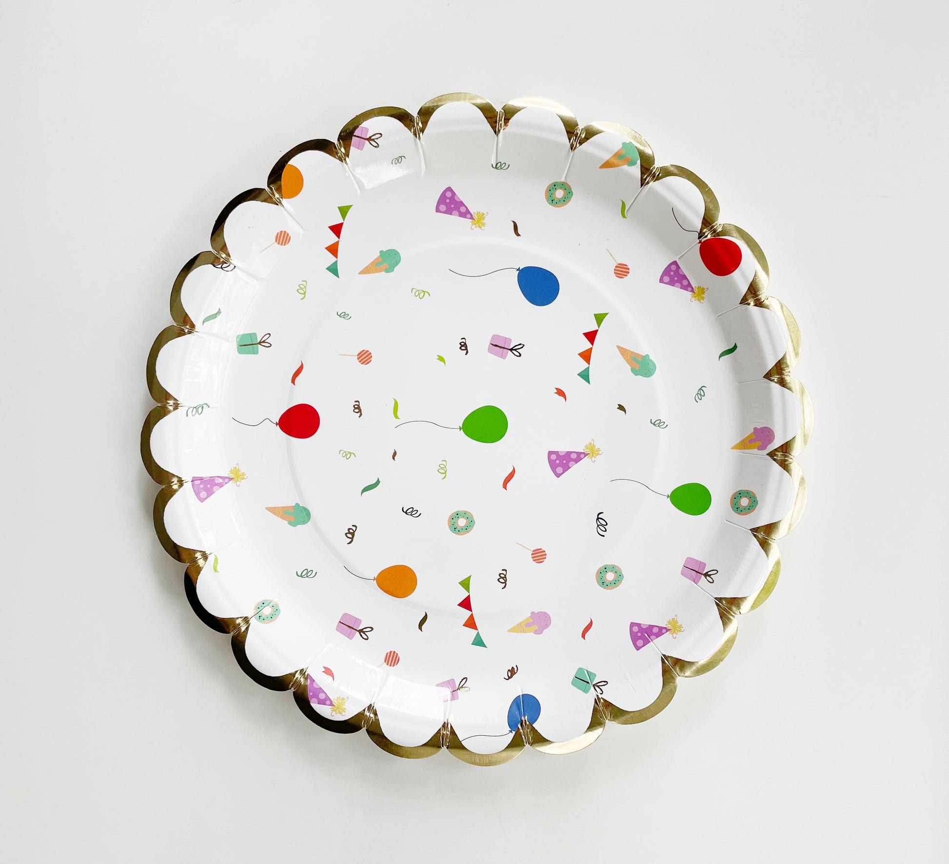 The small Celebration paper party plates have a gold foil scalloped edge. The celebration pattern features green, orange and blue balloons, ice cream cones, party hats, party garlands, birthday gifts and donuts.